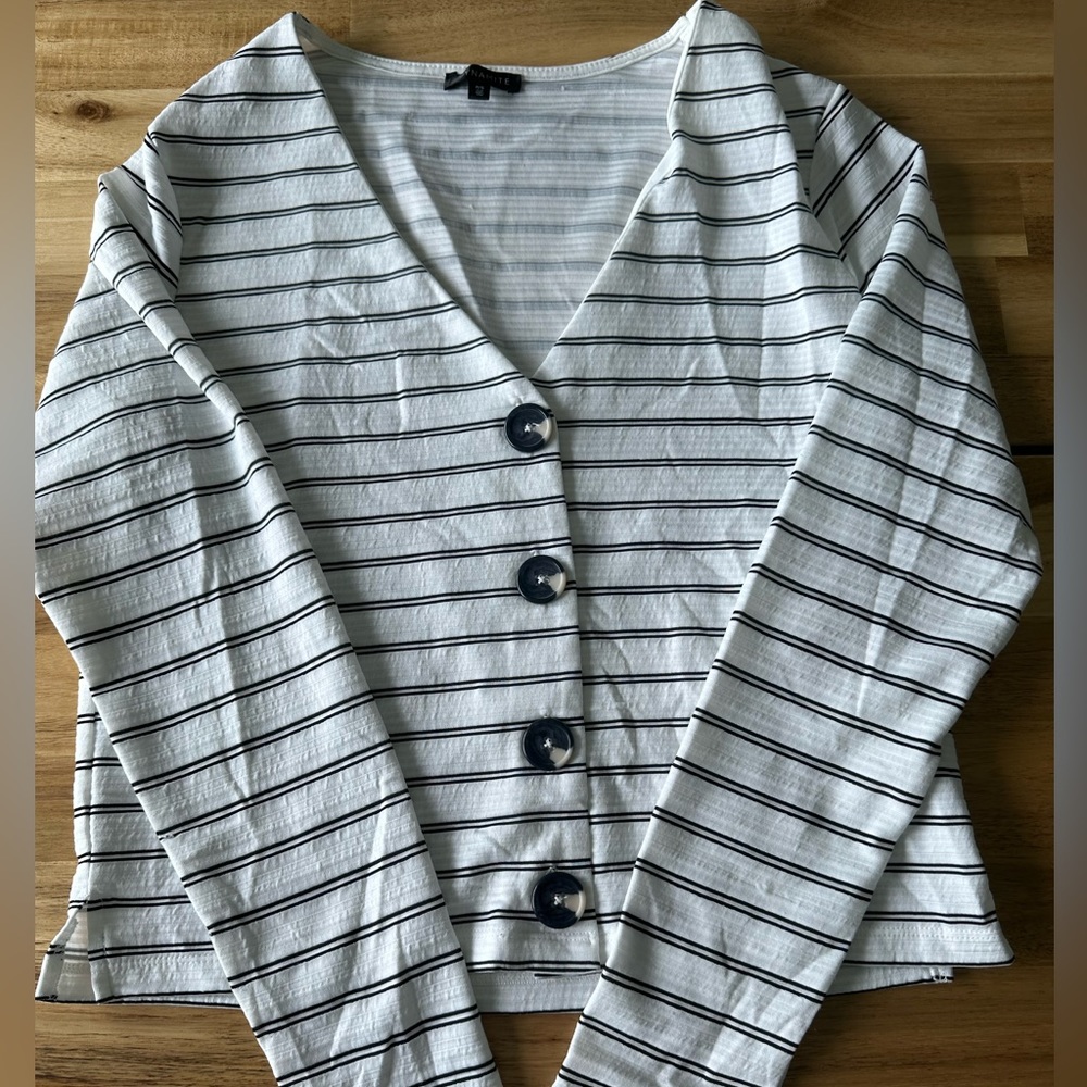 White and black striped shirt with buttons down the front.